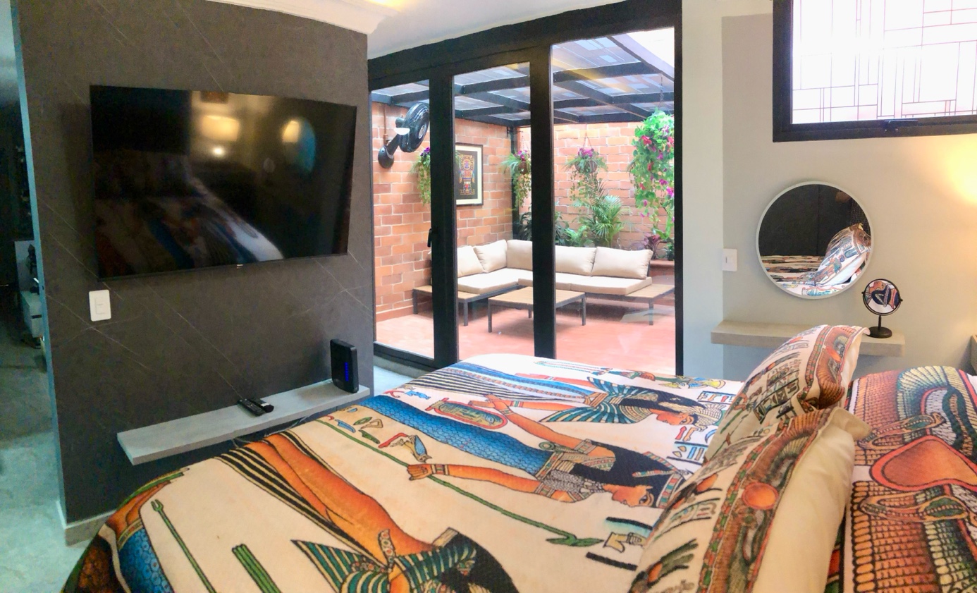 Bedroom with TV wall and French doors open to private terrace