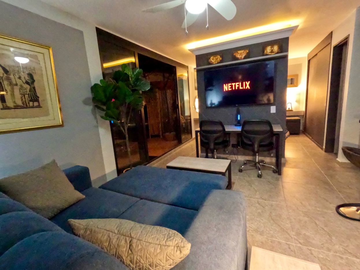 Living area and workspace at Oasis Laureles — Netflix on TV, terrace behind